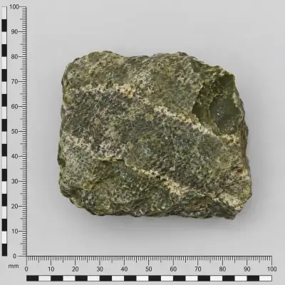 Customer specimen 06: mottled green block, photographed beside a millimeter scale