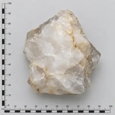 Customer specimen 09: milky white angular stone, photographed beside a millimeter scale