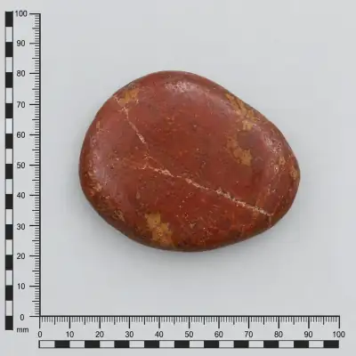 Customer specimen 13: red stone pebble, photographed beside a millimeter scale